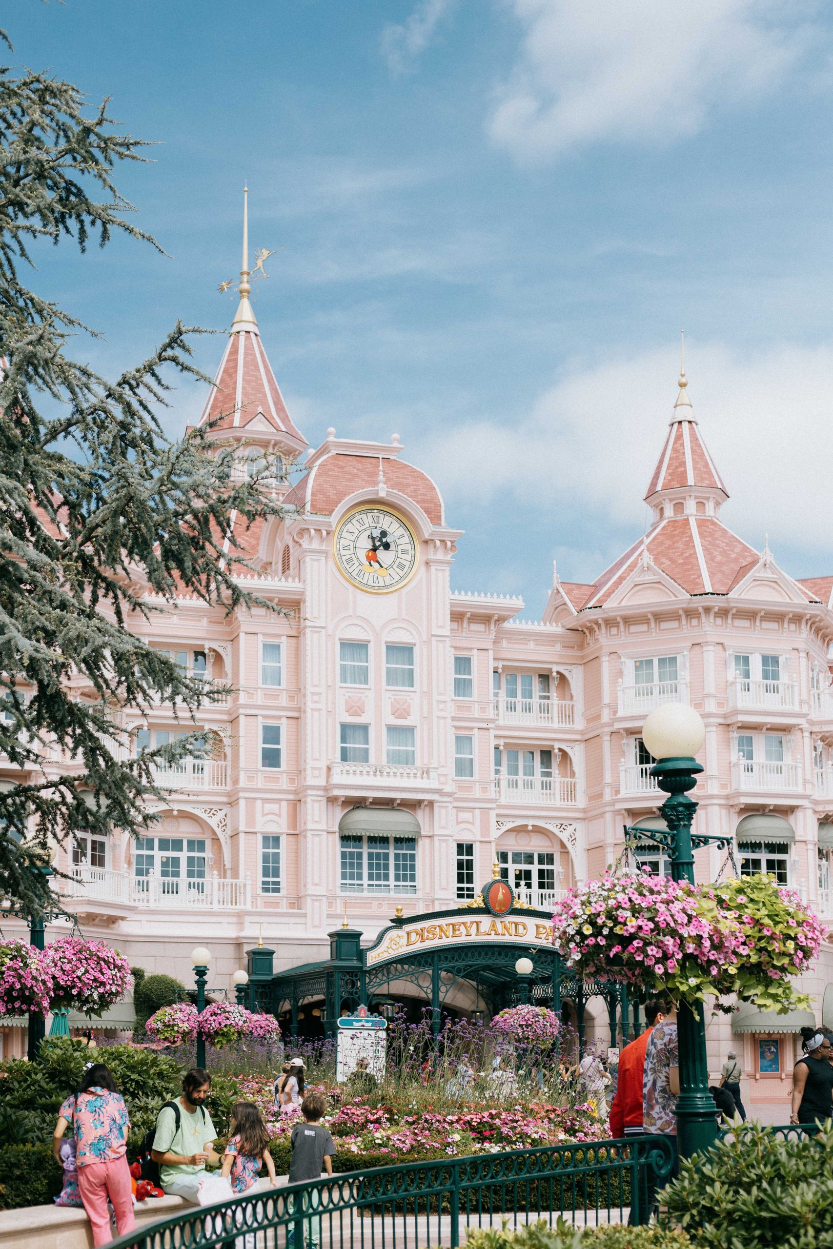 Charming Disneyland Paris hotel exterior on a sunny day with visitors in view.