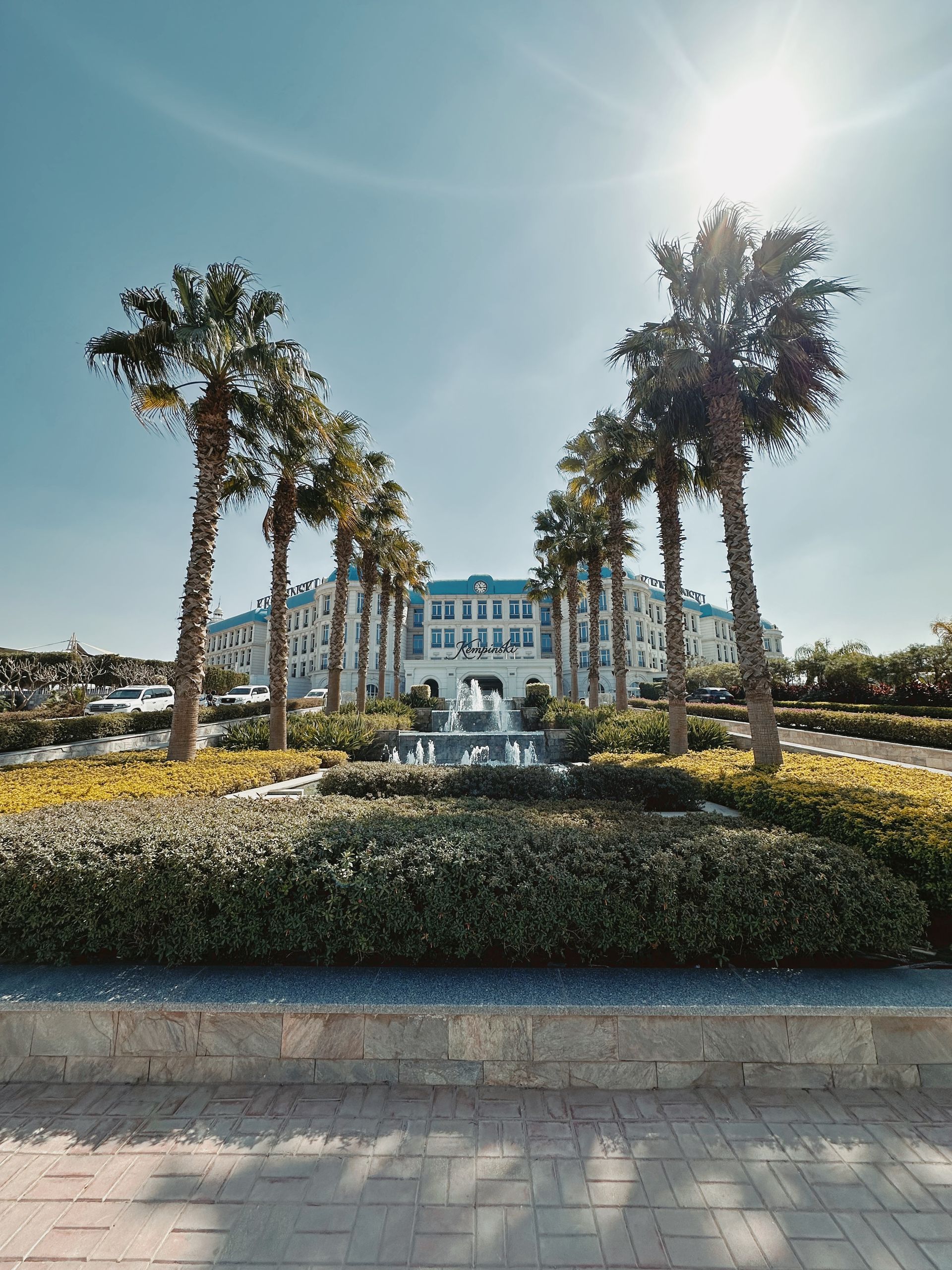 Stunning view of a grand hotel framed by palm trees under the bright sun in Egypt.
